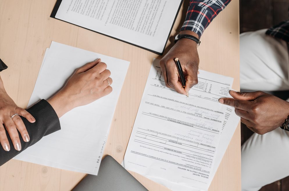 Verification documents being reviewed and signed off across a desk.